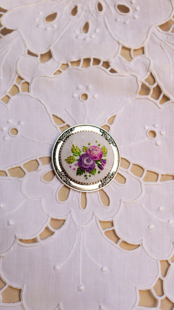 broche floral bordado em tons de roxo e rosa