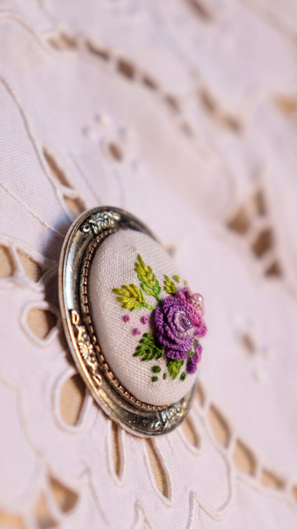 broche floral bordado em tons de roxo e rosa